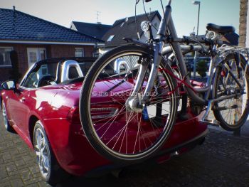 red fiat 124 spider with a bike rack fitted carrying a bike