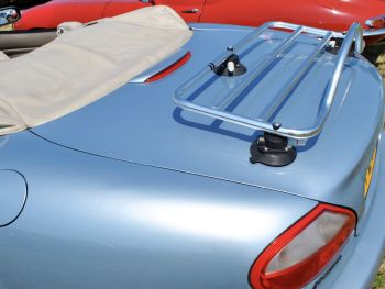 light blue jaguar xk8 convertible with the hood down and a revo-rack stainless steel luggage rack fitted on a sunny day