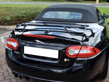 black jaguar xk convertible outside a Jaguar garage with a black luggage rack fitted