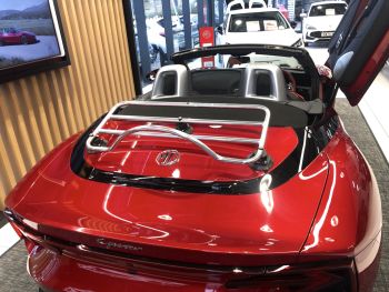 red mg cyberster with a rvo-rack pa chrome luggage rack fitted photographed close at the rear in an MG dealership